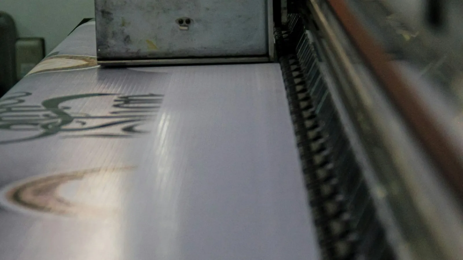 Imprimante numérique grand format imprimant un visuel sur un film transfert.